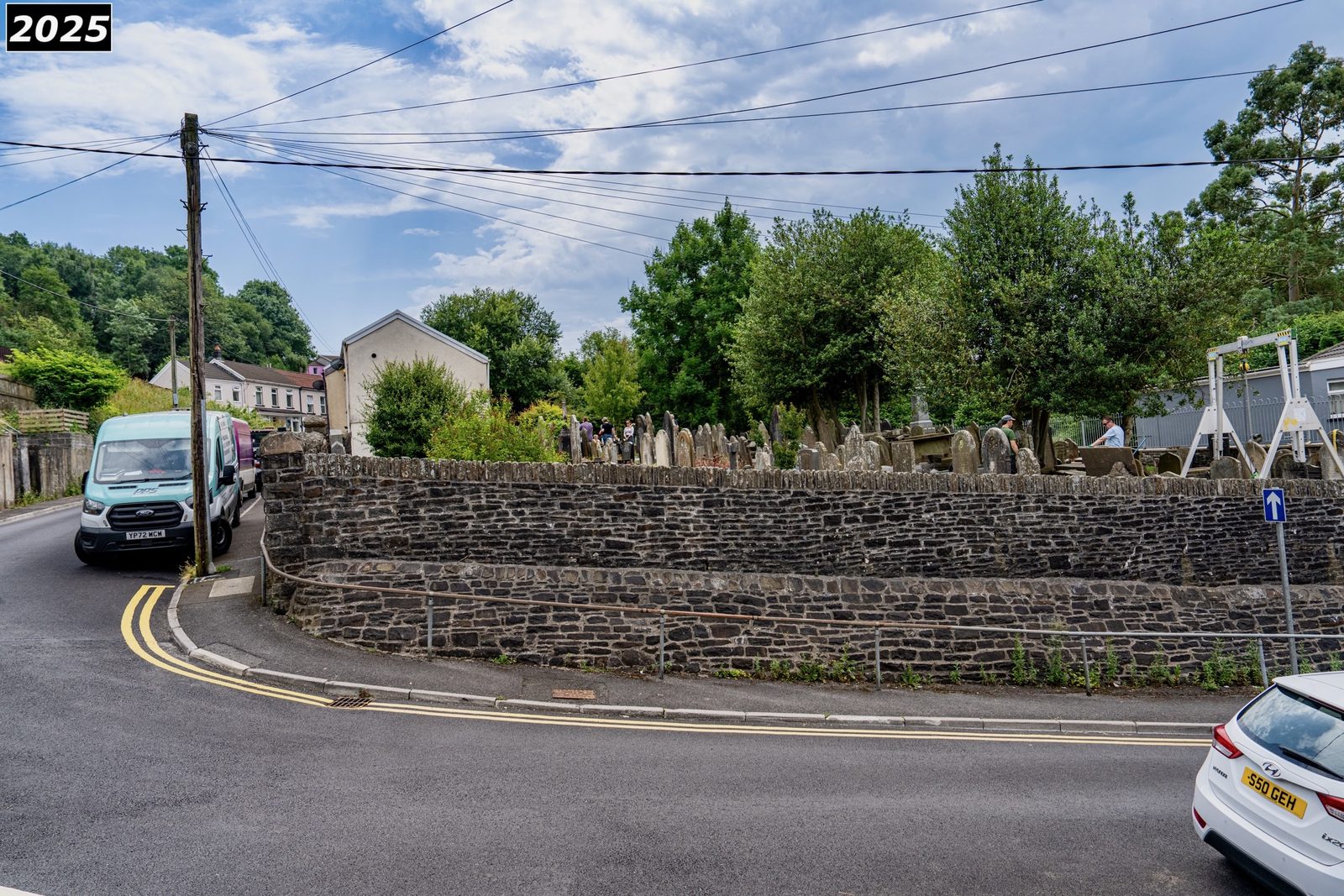 The restored boundary wall and tidy pavement at Saron graveyard in 2025