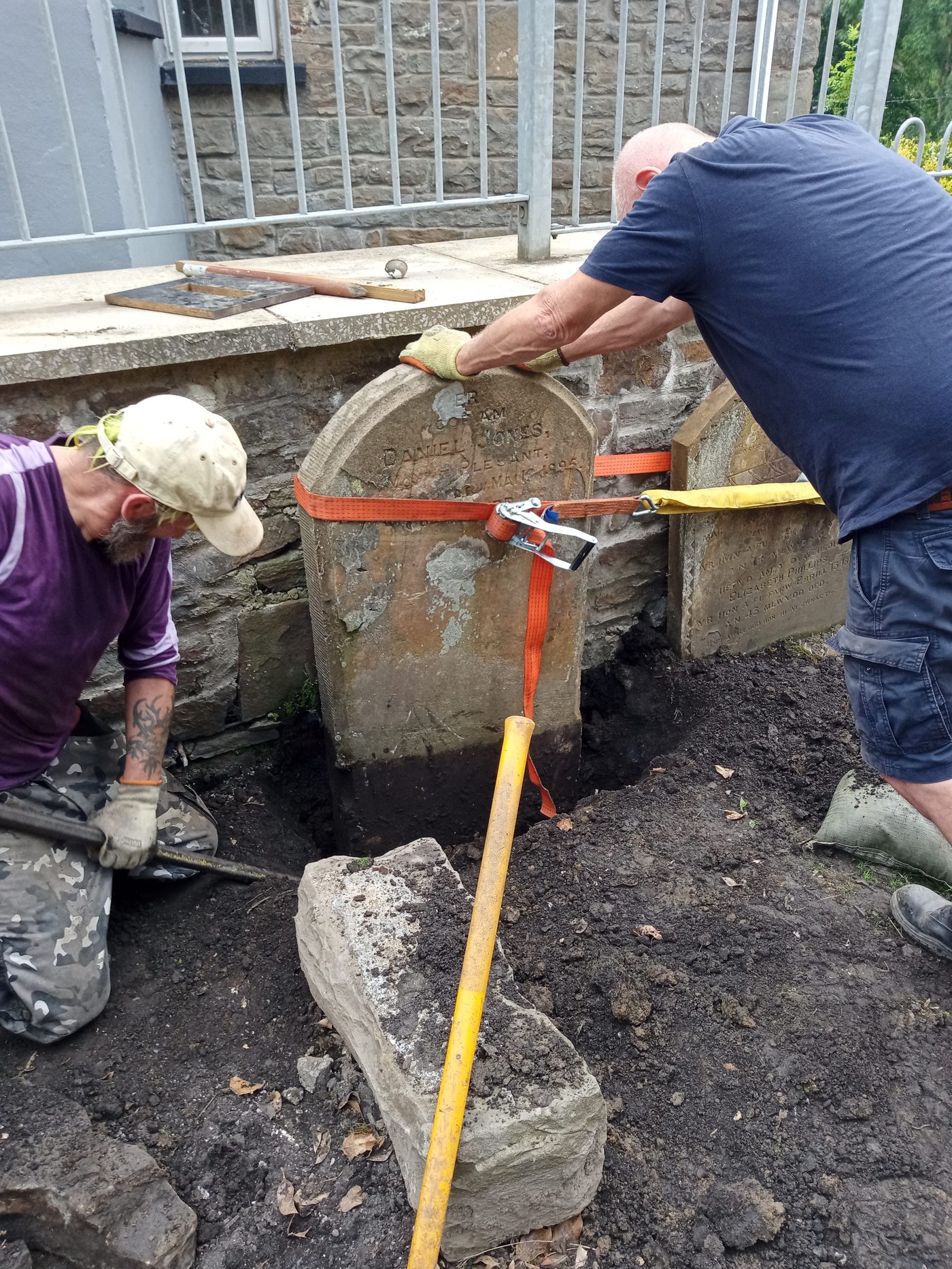 Volunteers resetting a headstone at Saron